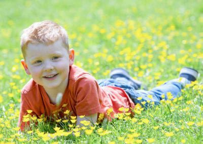 portrait photo of a young boy in a meadow