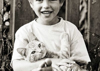 monochrome photo of boy holding a cat