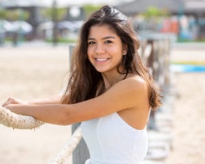 portrait photo of a college senior girl on a beach