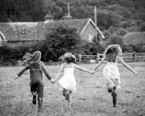 monochrome photo of 3 sisters running