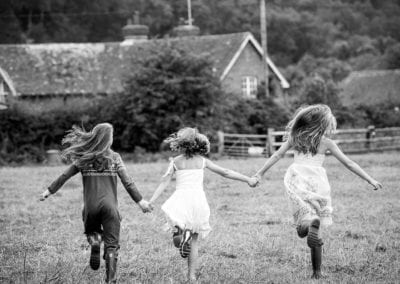 monochrome photo of 3 sisters running