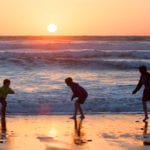 boys playing in the sea at sunset