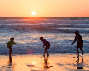 boys playing in the sea at sunset