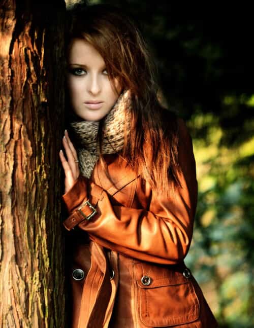 girl standing by a tree wearing a Karen Millen leather jacket