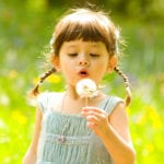Young girl holding a dandelion