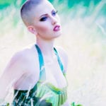 girl with a shaved head in green latex dress