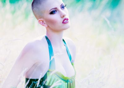 girl with a shaved head in green latex dress