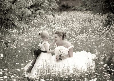 bride and child in field of daisies