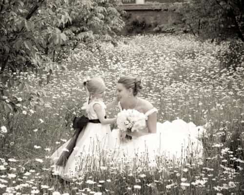 bride and child in field of daisies