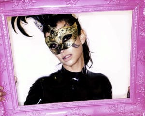 Catwoman in a latex costume framed by a pink picture frame